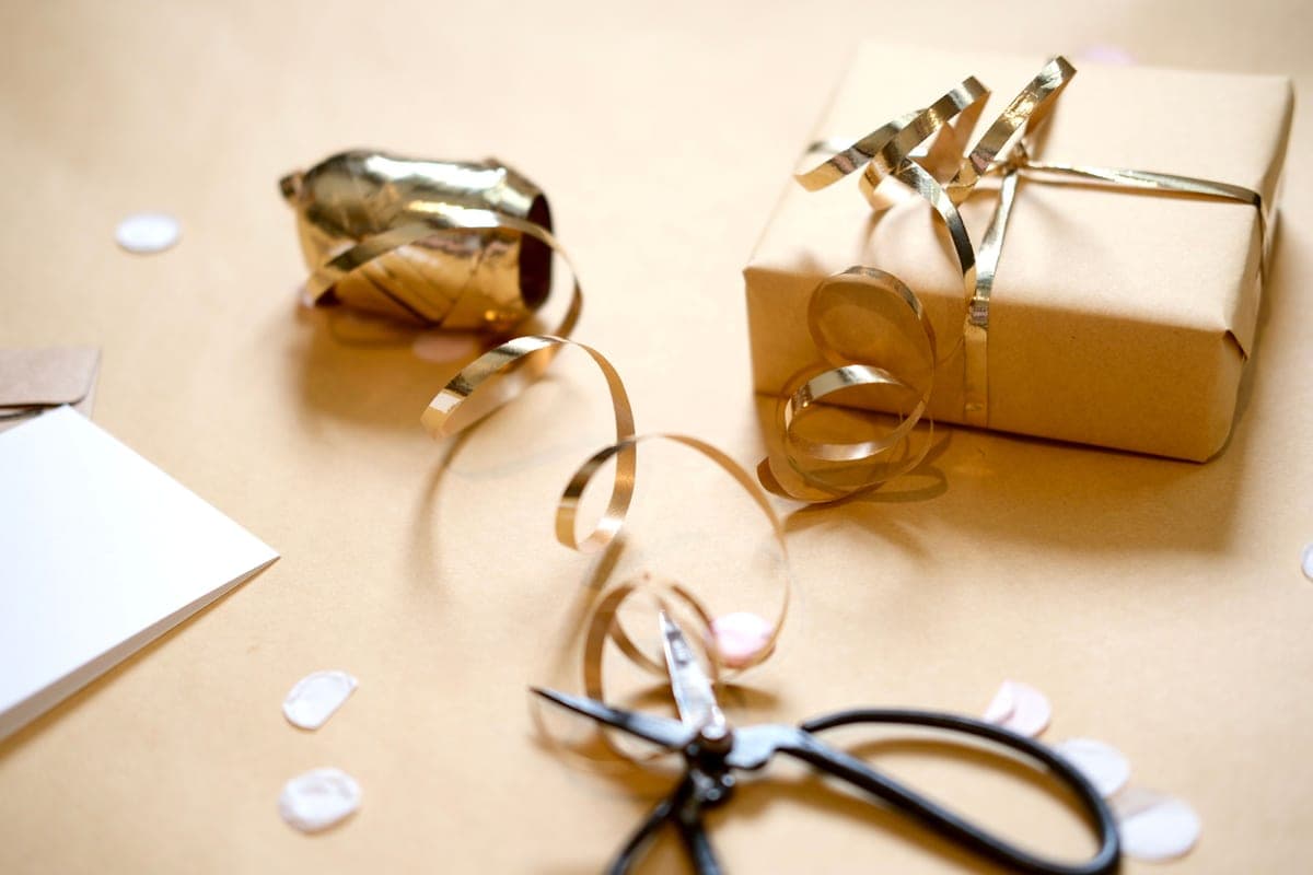 A wrapped gift box on a workbench surrounded by hand tools